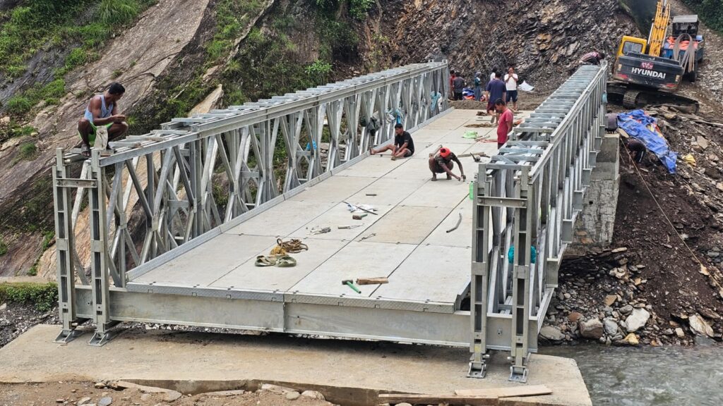 Galvanized steel deck plates and truss panels of a bailey bridge being installed by Inter Tech Pvt. Ltd. at Khungri, Rolpa, Nepal